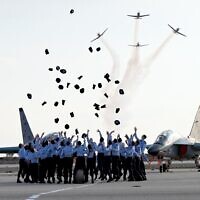 Israeli Air Force pilots throw their caps in the air during a graduation ceremony at the Hatzerim air force base, December 28, 2022. (Haim Zach/GPO)