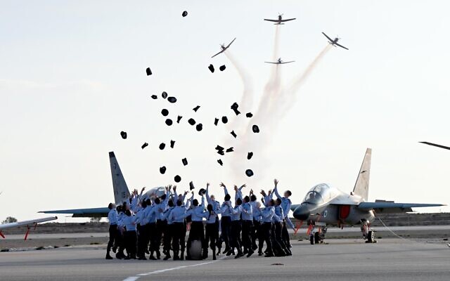 Illustrative: Israeli Air Force pilots throw their caps in the air during a graduation ceremony at the Hatzerim air force base, December 28, 2022. (Haim Zach/GPO)