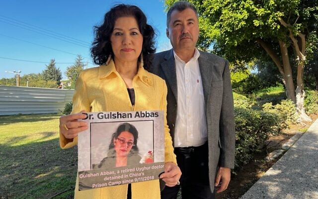 Rushan Abbas, left, holds a picture of her sister Gulshan Abbas, alongside her husband Abdulhakim Idris in Tel Aviv, on December 19, 2022. (Tal Schneider/Times of Israel)