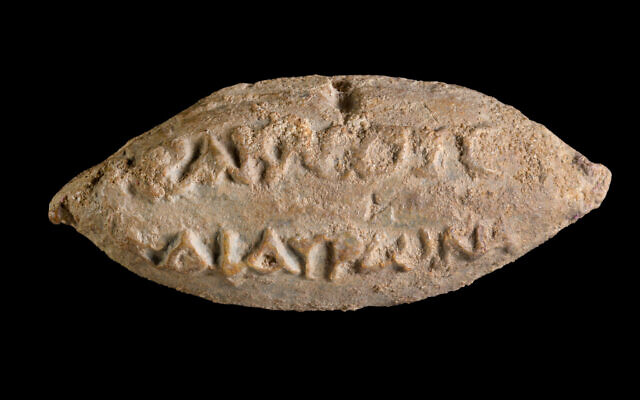 The names of the gods Heracles and Hauron on the reverse side of a
sling bullet found in Yavne. (Dafna Gazit/Israel Antiquities Authority)