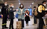 Chinese passangers wait in a line to have their COVID-19 vaccination documents examined as a preventive measure against coronavirus, after arriving at the Paris-Charles-de-Gaulle airport in Roissy, outside Paris, on January 1, 2023. (JULIEN DE ROSA / AFP)