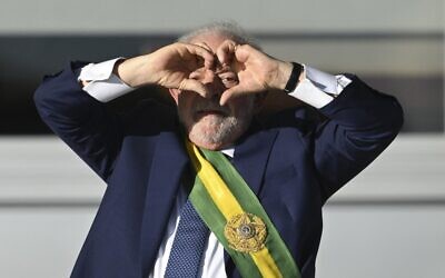 Brazil's new President Luiz Inacio Lula da Silva gestures at supporters making a heart sign with his hands at Planalto Palace after their inauguration ceremony at the National Congress, in Brasilia, on January 1, 2023. (EVARISTO SA / AFP)