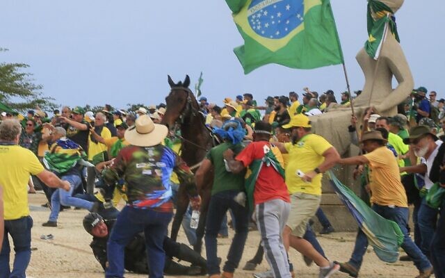A Military Police officer falls from his horse during clashes with supporters of Brazilian former President Jair Bolsonaro after an invasion to Planalto Presidential Palace in Brasilia on January 8, 2023. (Sergio Lima / AFP)