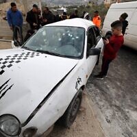 Onlookers surround a bullet-riddled car in which two Palestinian Islamic Jihad gunmen were killed by Israeli troops in Jaba' near the West Bank city of Jenin, on January 14, 2023. (Jaafar Ashtiyeh/AFP)