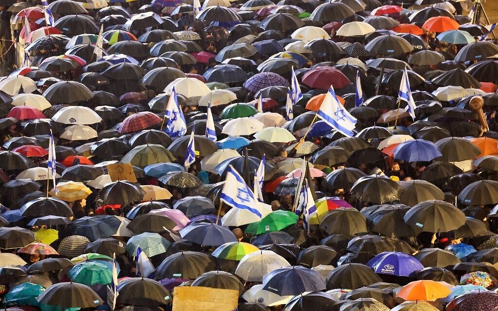 Israeli protesters carry umbrellas during a rally against Prime Minister Benjamin Netanyahu's new government in the coastal city of Tel Aviv on January 14, 2023. (Jack Guez/AFP)