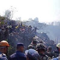 Rescuers gather at the site of a plane crash in the resort town of Pokhara, Nepal, January 15, 2023. (Yunish Gurung/AFP)