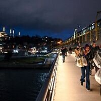 People walk on the Metro Bridge in Istanbul on January 24, 2023. (OZAN KOSE/AFP)