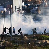 Israeli forces fire tear gas to disperse Palestinian demonstrators during clashes near Ramallah on January 26, 2023. (Ahmad Gharabli / AFP)