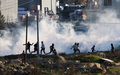 Israeli forces fire tear gas to disperse Palestinian demonstrators during clashes near Ramallah on January 26, 2023. (Ahmad Gharabli / AFP)