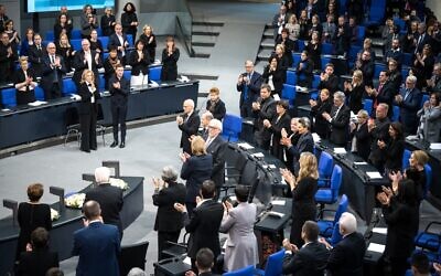 Klaus Schirdewahn (C R), representative of the LGBTQ community, receives applause during the annual ceremony in memory of Holocaust victims and survivors in the plenary hall of the Bundestag, the German lower house of parliament, in Berlin on January 27, 2023, on International Holocaust Remembrance Day. (Photo by STEFANIE LOOS / AFP)