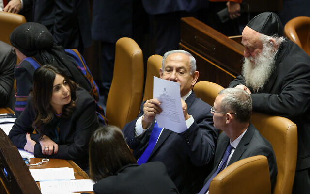 In this press photo, Prime Minister Benjamin Netanyahu speaks with other senior members of his ruling coalition during a Knesset plenum session, January 16, 2023. (Noam Moskowitz/ Knesset)
