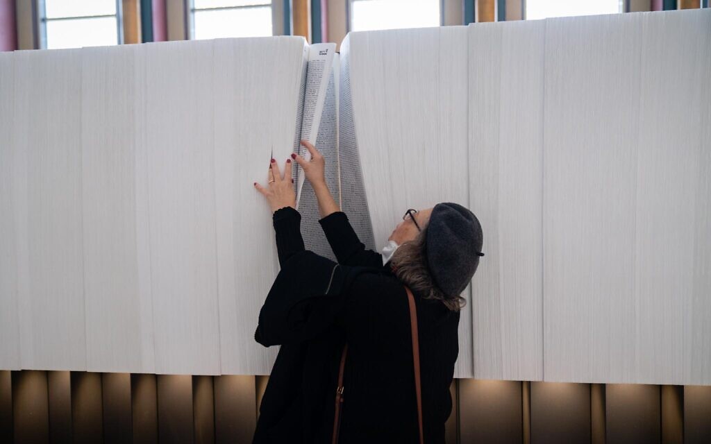 A woman looks through the Book of Names at UN Headquarters in New York, January 24, 2023. (Luke Tress/Times of Israel)