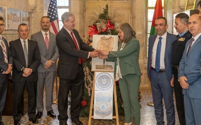 George Noll, head of the US Office of Palestinian Affairs, returns a looted "ceramic spoon" to Palestinian Authority Tourism and Antiquities Minister Rula Maayah, in the West Bank city of Bethlehem, January 5, 2022. (US Office of Palestinian Affairs)