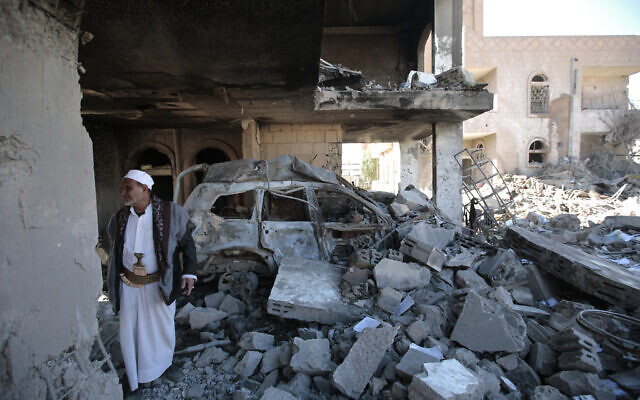 File: A man inspects the wreckage of a building after it was damaged in Saudi-led coalition airstrikes, in Sanaa, Yemen, January 18, 2022. (Hani Mohammed/AP)