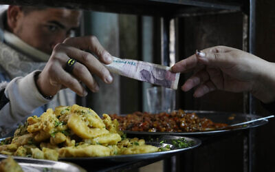 A man buys food at a restaurant in Cairo, Egypt, March 22, 2022. (AP Photo/Amr Nabil, File)