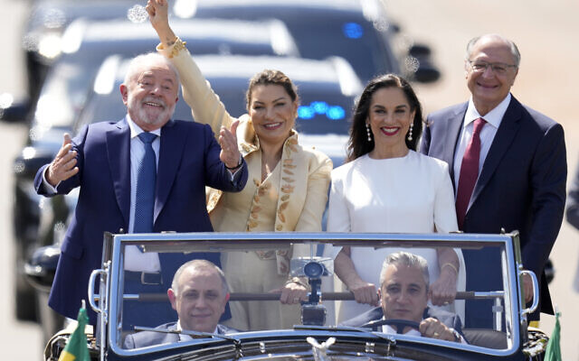 President-elect Luiz Inacio Lula da Silva, left, his wife Rosangela Silva, second from left, Vice President-elect Geraldo Alckmin, right, and his wife Maria Lucia Ribeiro, ride in an open car to congress for their swearing-in ceremony in Brasilia, Brazil, on January 1, 2023. (AP Photo/Andre Penner)