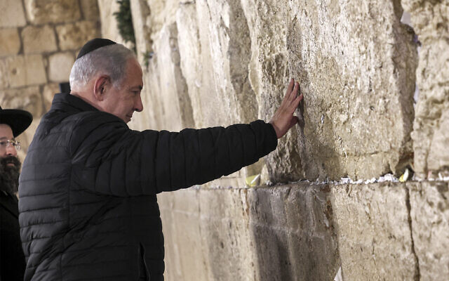 Prime Minister Benjamin Netanyahu prays as he visits the Western Wall in the Old City of Jerusalem, January 1, 2023. (Gil Cohen-Magen/Pool via AP)