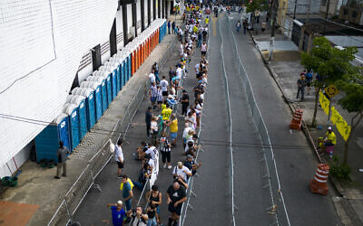 Soccer fans line up to attend the funeral of the late Brazilian soccer legend Pele at the Vila Belmiro stadium in Santos, Brazil, Jan. 2, 2023. (AP Photo/Matias Delacroix)