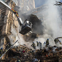 Firefighters work after a drone attack on buildings in Kyiv, Ukraine, October 17, 2022. (Roman Hrytsyna/AP)