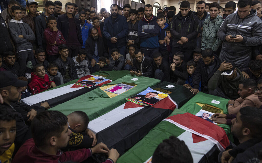 Mourners gather around the coffins of four out of eight Palestinian migrants who died off the Tunisian coast, during their funeral at a mosque in Rafah in the southern Gaza Strip, December 18, 2022. (AP/Fatima Shbair)