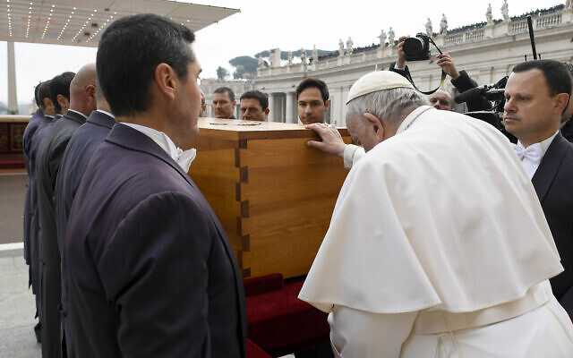 In this image released on Thursday, Jan. 5, 2023, by the Vatican Media news service, Pope Francis touches the coffin of late Pope Emeritus Benedict XVI after his funeral mass in St. Peter's Square at the Vatican, Thursday, Jan. 5, 2023. Benedict died at 95 on Dec. 31 in the monastery on the Vatican grounds where he had spent nearly all of his decade in retirement. He was 95. (Vatican Media via AP)