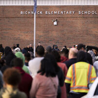 Students and police gather outside of Richneck Elementary School after a shooting, Friday, Jan. 6, 2023 in Newport News, Va. (Billy Schuerman/The Virginian-Pilot via AP)