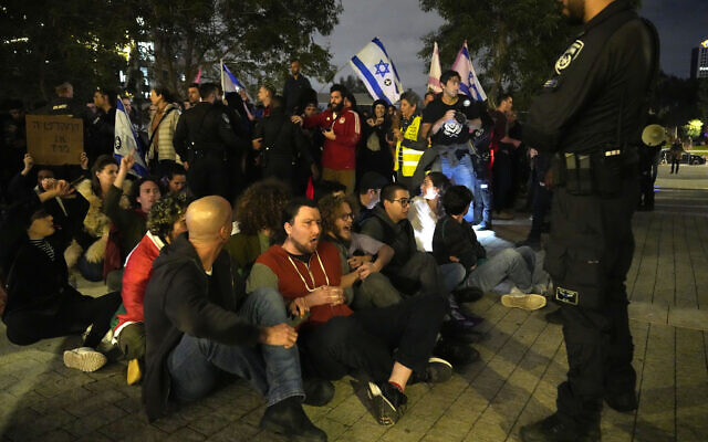 Activists lock arms in Tel Aviv to protest the government, January 7, 2023. (AP/Tsafrir Abayov)