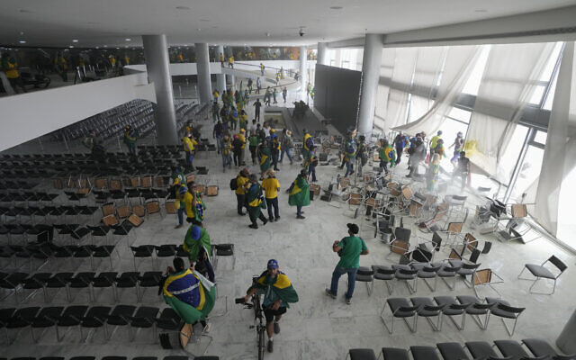 Protesters, supporters of Brazil's former President Jair Bolsonaro, storm the Planalto Palace in Brasilia, Brazil, Sunday, Jan. 8, 2023. (AP Photo/Eraldo Peres)