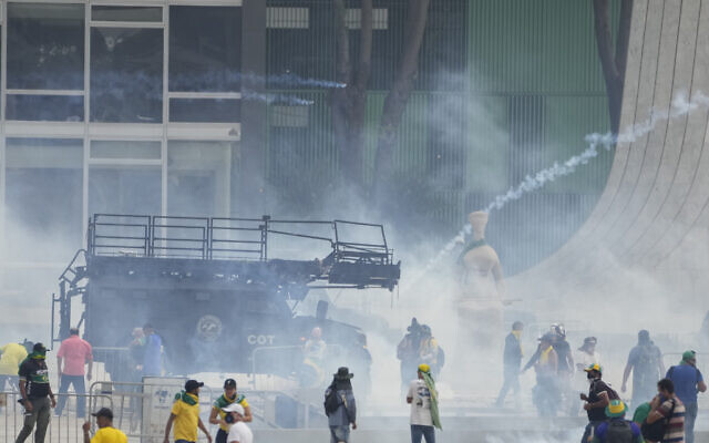 Supporters of Brazil's former President Jair Bolsonaro clash with the police after they stormed the Planalto Palace in Brasilia, Brazil, January 8, 2023. (AP Photo/Eraldo Peres)