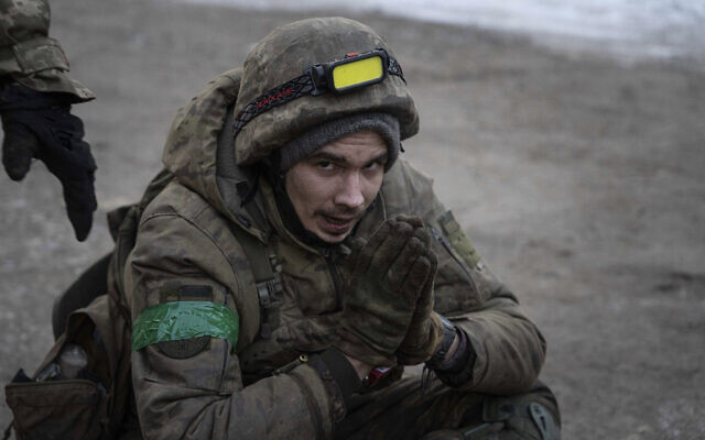 A Ukrainian military medic sits on the ground as he is evacuated with his injured comrades from the battlefield into a hospital in Donetsk region, Ukraine, January 9, 2023. (AP Photo/Evgeniy Maloletka)
