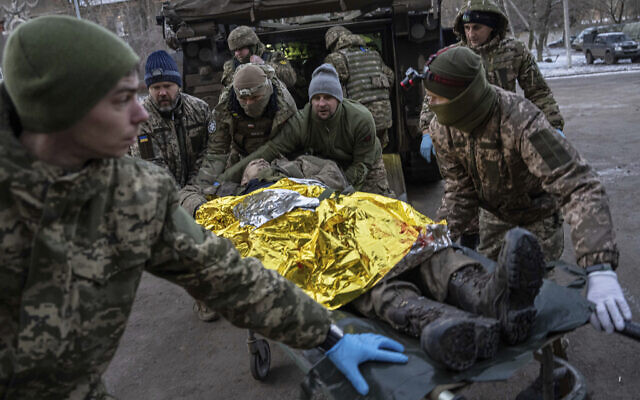 Ukrainian military medics carry an injured Ukrainian serviceman evacuated from the battlefield into a hospital in Donetsk region, Ukraine, January 9, 2023. The serviceman did not survive. (AP Photo/Evgeniy Maloletka)