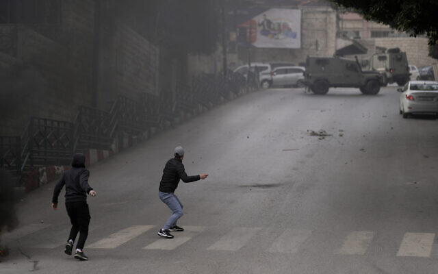 Palestinians clash with Israeli security forces during an army operation in the West Bank city of Nablus, January 12, 2023. (AP Photo/Majdi Mohammed)