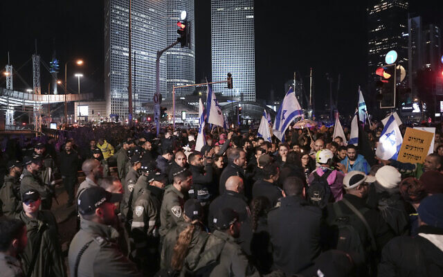 Police officers prevent protesters from blocking a highway during a rally against the government's plans to overhaul the country's legal system, in Tel Aviv, January 14, 2023. (AP Photo/Oded Balilty)