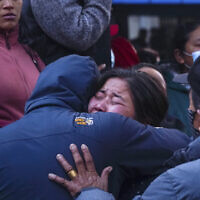 A woman cries as the body of a relative, victim of a plane crash, is brought to a hospital in Pokhara, Nepal, January 15, 2023. (AP Photo/Yunish Gurung)