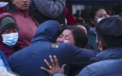 A woman cries as the body of a relative, victim of a plane crash, is brought to a hospital in Pokhara, Nepal, January 15, 2023. (AP Photo/Yunish Gurung)