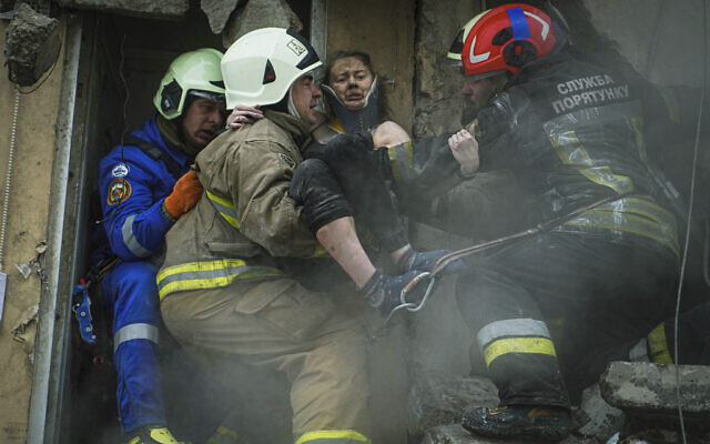 In this photo released by State Emergency Service of Ukraine on January 16, 2022, Ukrainian State Emergency Service firefighters carry a wounded woman out of the rubble from a building after a Russian rocket attack in Dnipro, Ukraine, January 15, 2023. (Pavel Petrov, SESU via AP)