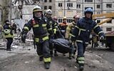 Rescue workers carry the body of a man who was killed in a Russian missile strike on an apartment building in the southeastern city of Dnipro, Ukraine, Janyary 16, 2023. (Evgeniy Maloletka/AP)