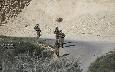 Soldiers patrol the scene after a Palestinian was shot and killed following an alleged attempted attack on an Israeli, next to Sde Efraim farm in the West Bank, Saturday, January 21, 2023. (AP Photo/Mahmoud Illean)