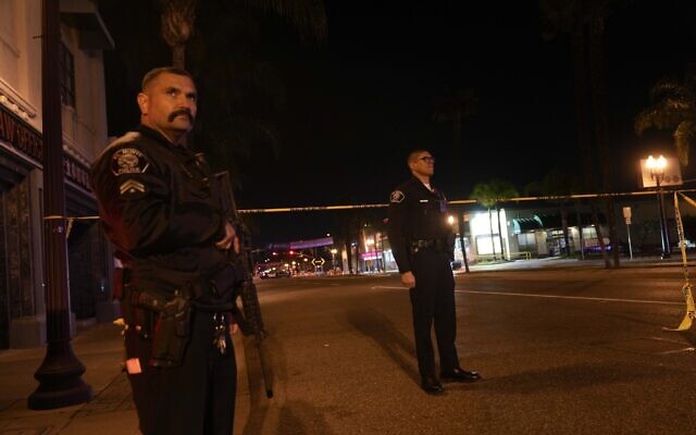 Two police officers stand guard near a scene where a shooting took place in Monterey Park, California, January 22, 2023. (AP/Jae C. Hong)
