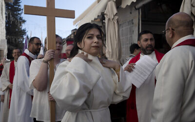 Sally Ibrahim Azar, center, a Palestinian Christian and Council member of the Lutheran World Federation checks her collar before the procession for her ordination as the first female pastor in the Holy Land, in the Old City of Jerusalem, January 22, 2023. (AP Photo/Maya Alleruzzo)