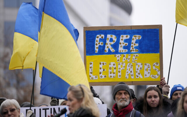 Protestors hold signs and wave Ukrainian flags during a demonstration in support of Ukraine outside of an EU foreign ministers meeting at the European Council building in Brussels on Monday, January 23, 2023. (AP Photo/Virginia Mayo)