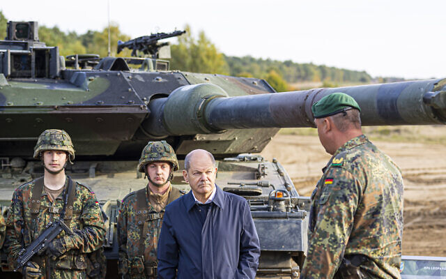 German Chancellor Olaf Scholz stands with German army Bundeswehr soldiers at a 'Leopard 2' main battle tank during a training and instruction exercise in in Ostenholz, Germany, October 17, 2022. (Moritz Frankenberg/dpa via AP, File)