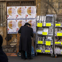 An ultra-Orthodox Jewish man buys disposable plastic dishes in Jerusalem's Mea Shearim neighborhood, January 20, 2023. (Oded Balilty/AP)