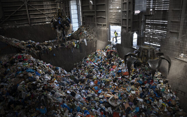 Cranes lift waste, mostly plastic and paper at the GreenNet recycling plant in Atarot industrial zone, north of Jerusalem, January 25, 2023. (Oded Balilty/AP)