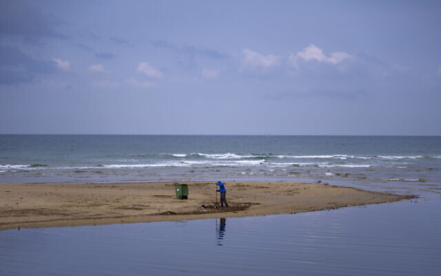 A Tel Aviv's municipality worker cleans the beach from plastic waste, in Tel Aviv, January 9, 2023. (Oded Balilty/AP)
