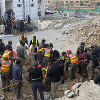 Security officials and rescue workers search bodies at the site of suicide bombing, in Peshawar, Pakistan, Monday, Jan. 30, 2023.(AP/Zubair Khan)