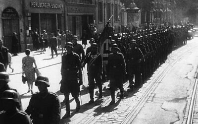 German troops carrying a Nazi flag enter the Polish town of Lodz, October 9, 1939. (AP Photo/Pool/Paramount News)