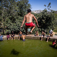 People enjoy a hot summer day at the Ein Lavan Spring in the Jerusalem Mountains, July 28, 2021. (Yonatan Sindel/Flash90)