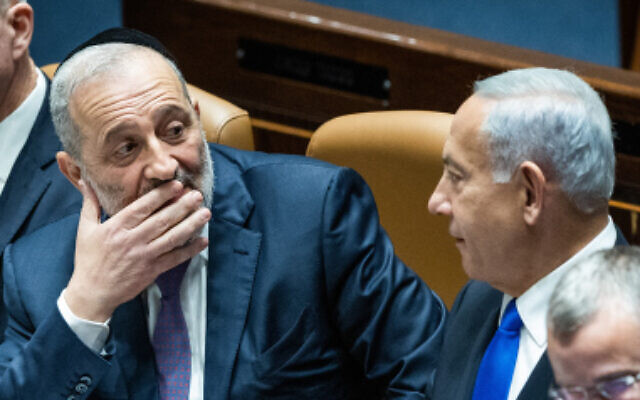 Prime Minister Benjamin Netanyahu with Minister of the Interior and Health Aryeh Deri during the swearing in ceremony of the new government at the Knesset, on December 29, 2022. (Yonatan Sindel/Flash90)
