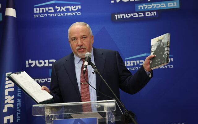 Yisrael Beytenu party head Avigdor Liberman speaks during his party's Knesset faction, holding a copy of the recently signed coalition agreements in his left hand and a copy of Theodor Herzl's The Jewish State in his right, January 2, 2023. (Yonatan Sindel/Flash90)
